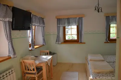 a living room with a table and a tv at Farmhouse Štiftar in Solčava