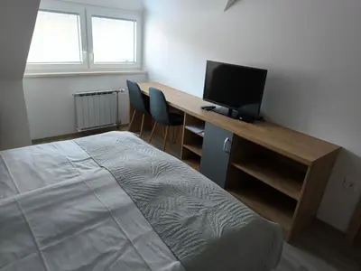 a bedroom with a desk with a computer and a bed at Guesthouse Haler in Podčetrtek