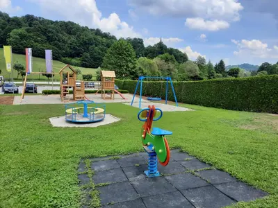 a park with a playground with a swing at Guesthouse Haler in Podčetrtek