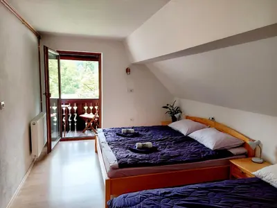a bedroom with a bed with a purple comforter at Apartments Sušnik in Bohinj