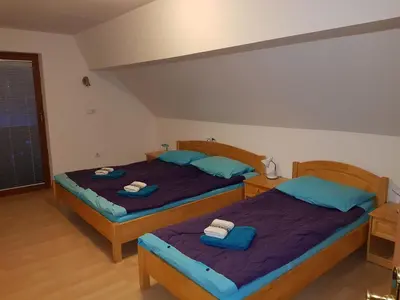 two beds in a room with blue pillows at Apartments Sušnik in Bohinj