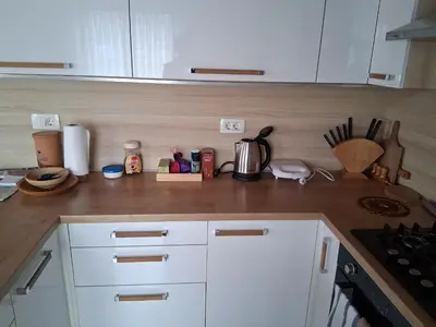 a kitchen with white cabinets and a counter top at Rooms Apartma Cerknica in Cerknica