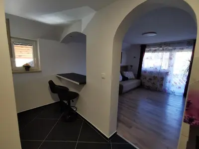 a room with a chair and a table and a couch at Apartments Bernard in Bled