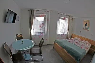 a bedroom with a bed and a table and chairs at Apartments Bernard in Bled