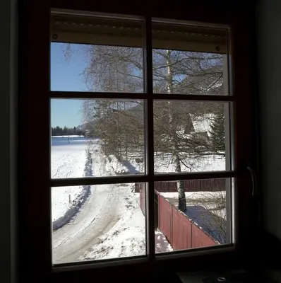 a window looking out at a snow covered road at Apartment Brina in Kranjska Gora