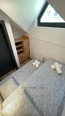 a bedroom with a bed with two pillows on it at Apartma Zala, Golte in Mozirska Koča