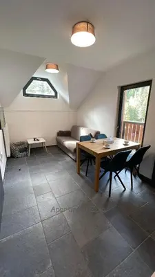 a living room with a table and a couch at Apartma Zala, Golte in Mozirska Koča