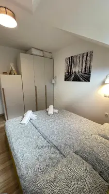 a bedroom with a bed and a painting on the wall at Apartma Zala, Golte in Mozirska Koča