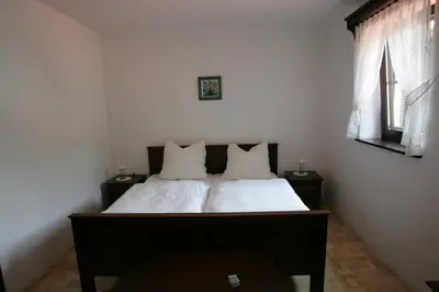 a bedroom with a bed with white sheets and pillows at Farm Stay Frank Ozmec Wine and Glamping estate in Ljutomer