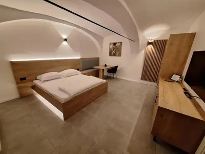 a bedroom with a bed and a table in a room at Prenočišča Kralj in Komenda