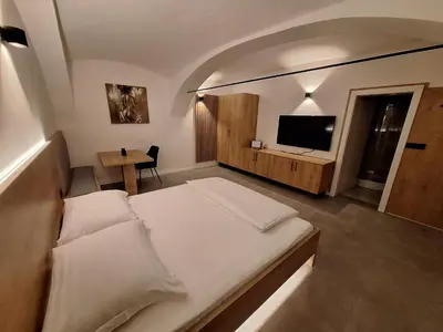 a bedroom with a large bed and a television at Prenočišča Kralj in Komenda