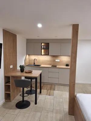 a kitchen with a table and a sink and a counter at Prenočišča Kralj in Komenda