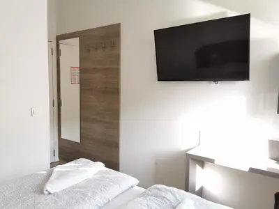 a bedroom with a bed with a television on the wall at Rooms Ambrožič in Ljubljana