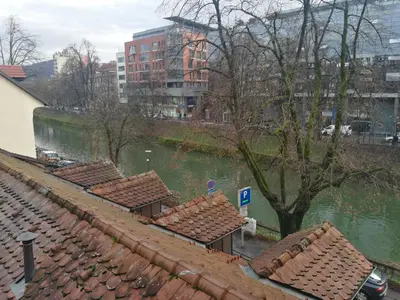 a row of roofs next to a body of water at Rooms Ambrožič in Ljubljana