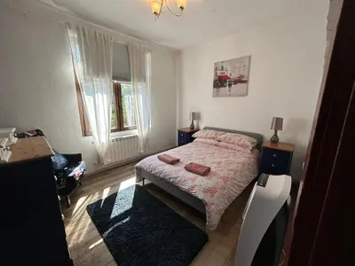 a bedroom with a bed and a tv in it at 22 - The Old Workshop with fired wood hot tub in Tolmin