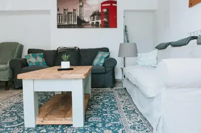a living room with a couch and a table at 22 - The Old Workshop with fired wood hot tub in Tolmin