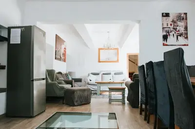 a living room with chairs and a refrigerator at 22 - The Old Workshop with fired wood hot tub in Tolmin