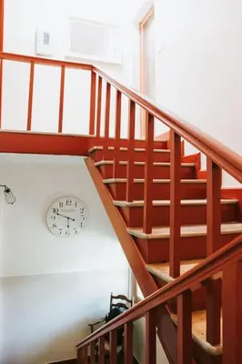 a wooden staircase with a clock on the wall at 22 - The Old Workshop with fired wood hot tub in Tolmin