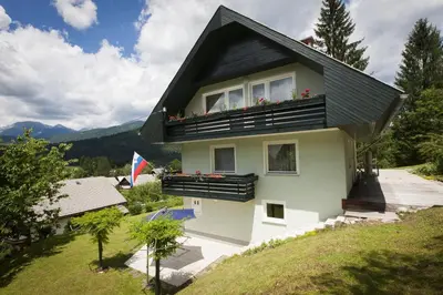 a house with a balcony with flowers on it at Home with views on Alps in Bohinj