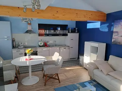 a kitchen and living room with a table and a couch at Apartma Jaka in Ljubljana