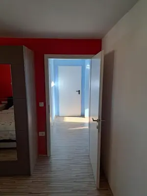 an empty room with red walls and an open door at Apartma Jaka in Ljubljana
