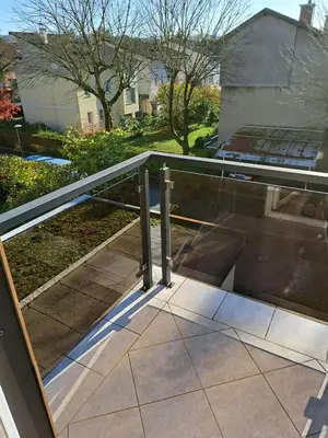 a glass railing on a balcony with a house at Apartma Jaka in Ljubljana