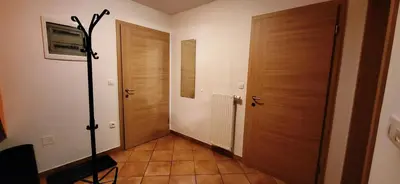 a hallway with two wooden doors and a tile floor at Apartments Oman in Kranjska Gora