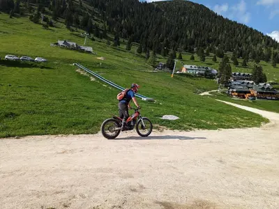 a man riding a bike on a dirt road at M & M apartment Krvavec in Cerklje na Gorenjskem
