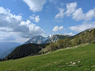 a green field with mountains in the background at M & M apartment Krvavec in Cerklje na Gorenjskem