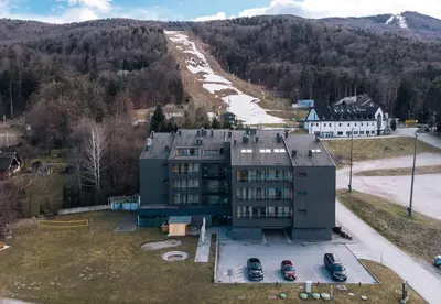a building with cars parked in a parking lot at Villa Mari - apartma št. 6 in Maribor