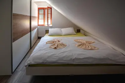 a bedroom with a bed with two towels on it at Apartmaji Pr' Kopavank in Rateče