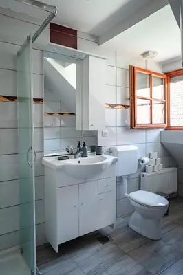 a bathroom with a white sink and a toilet at Apartmaji Pr' Kopavank in Rateče
