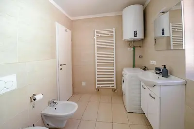 a white bathroom with a sink and a toilet at Apartmaji Pr' Kopavank in Rateče