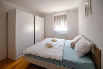 a small bedroom with a bed with towels on it at Apartmaji Pr' Kopavank in Rateče
