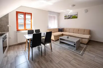 a living room with a couch and a table and chairs at Apartmaji Pr' Kopavank in Rateče