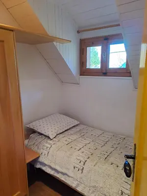 a small bedroom with a bed and a window at Bohinj, Metka - vacation house Pri Metki in Bohinj