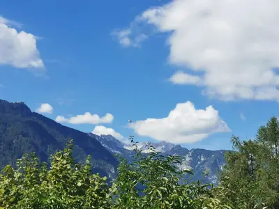 a view of a mountain range with trees and clouds at Bohinj, Metka - vacation house Pri Metki in Bohinj