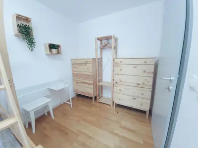 a room with a mirror and some dressers and a table at Apartma M&J in Mojstrana