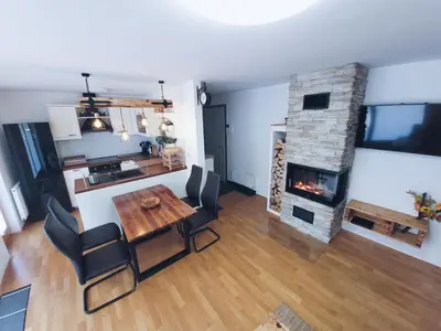 a living room with a table and a fireplace at Apartma M&J in Mojstrana