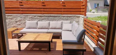 a couch and a coffee table on a patio at Apartma M&J in Mojstrana