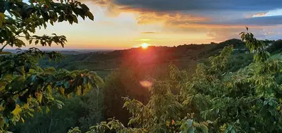 a sunset in the mountains with the sun setting at Olivea in Dobrovo