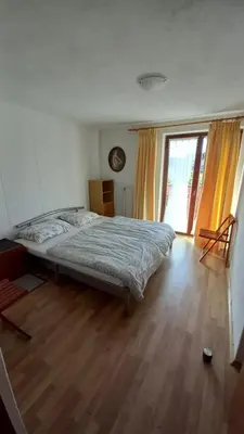 a bedroom with a bed and a wooden floor at Draga - 2 bedroom apartment in Tržič