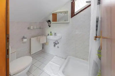 a white bathroom with a toilet and a sink at Bed and Breakfast Mili Vrh in Kamnik