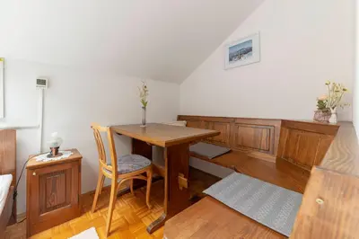 a dining room with a wooden table and chairs at Bed and Breakfast Mili Vrh in Kamnik