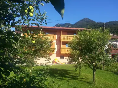 a building with a yard with trees in front of it at Apartments Masera in Kobarid