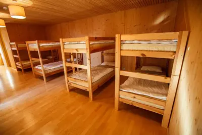 a room with four bunk beds in a cabin at Youth Hostel Punkl in Ravne na Koroškem