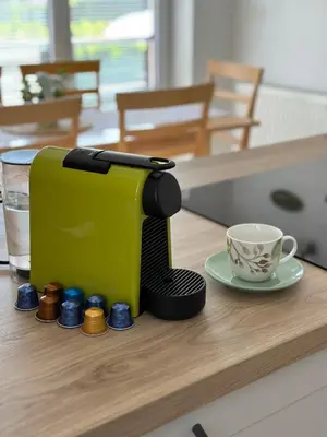 a green toaster sitting on a counter next to a cup at Apartmaji Koman in Bled