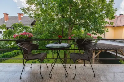 a table and chairs on a balcony with flowers at Apartmaji Koman in Bled