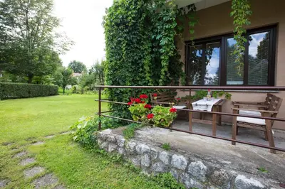 a house with a balcony with a table and flowers at Apartmaji Koman in Bled