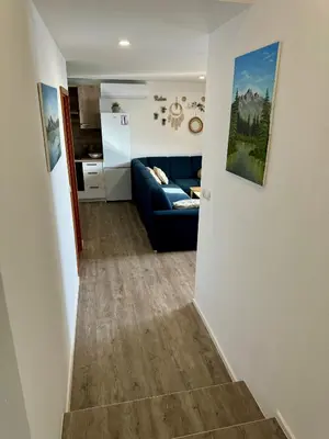 a living room with a blue couch and a kitchen at Sunny Oak Estate in Mengeš